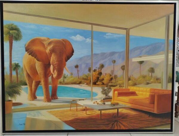 Interior living room with a glass wall, orange sofa and coffee table, and an elephant by a pool outside against a desert landscape.
